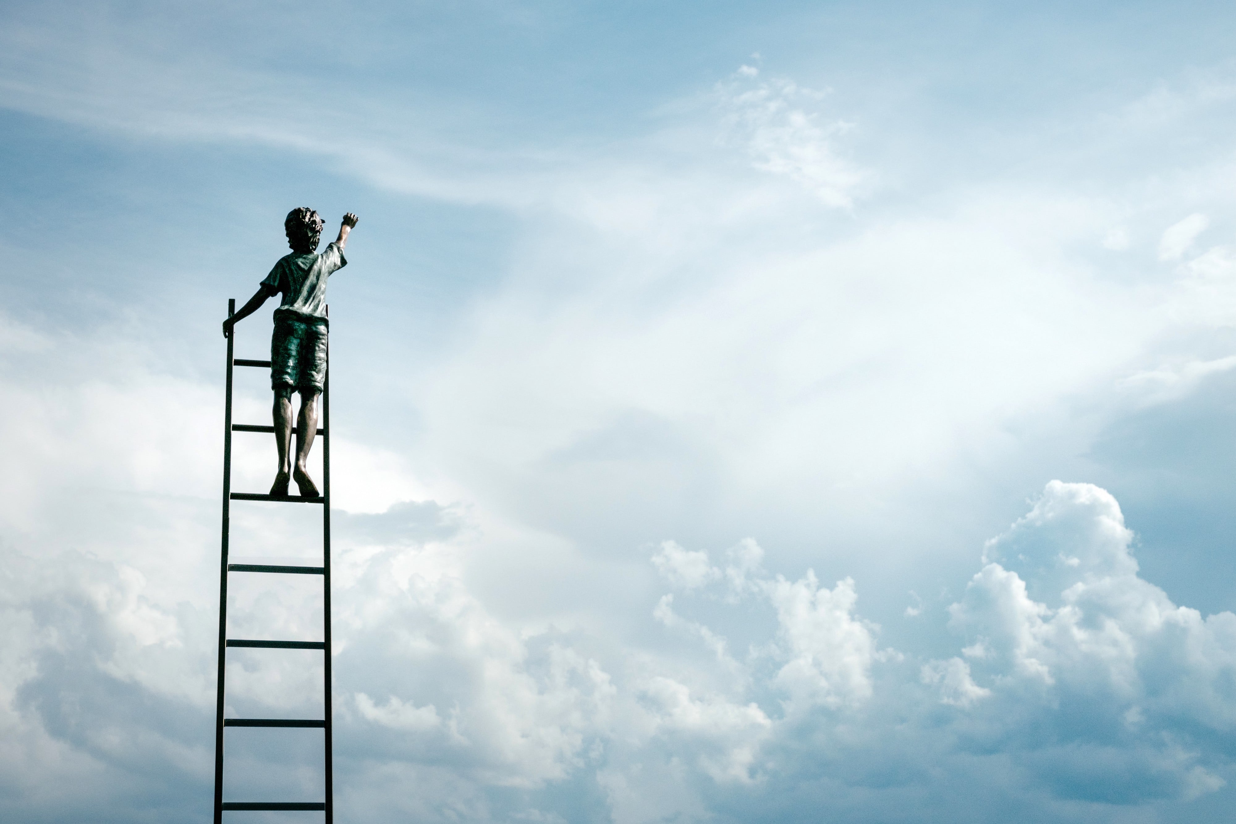 “A person standing on top of a ladder in the clouds.” by Samuel Zeller on Unsplash